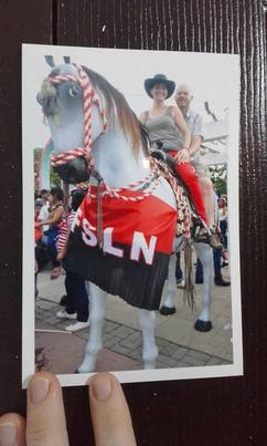 Picture of Brian and Sara atop a fake horse at the Dia de la Revolucion celebrating.